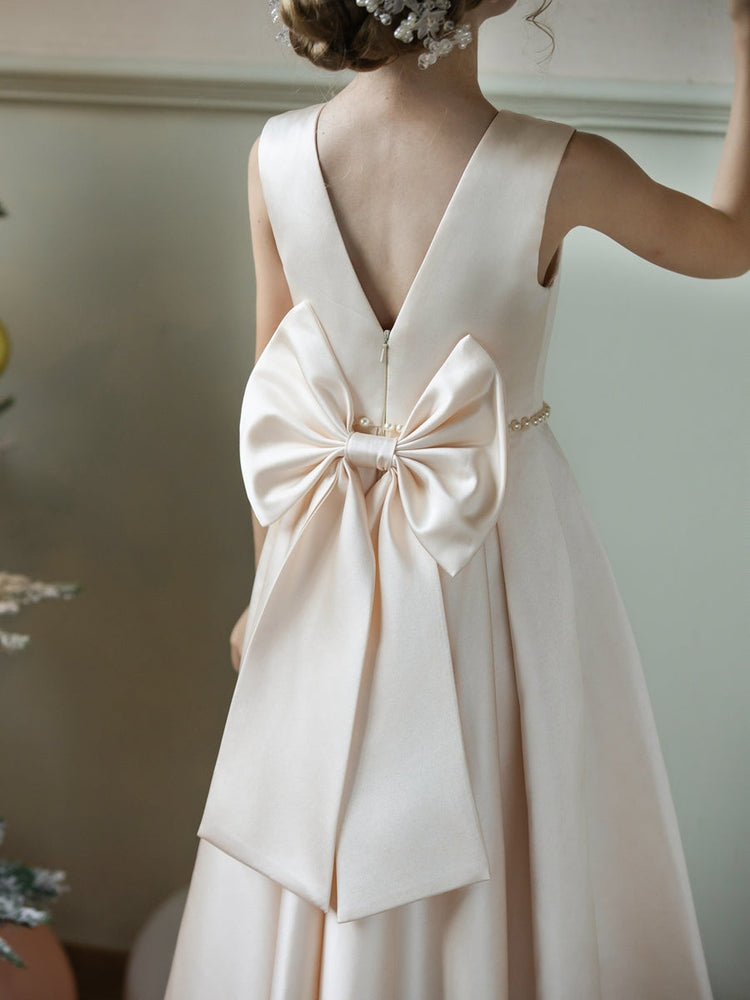Sleeveless round neck matte satin, pearl waist sash, long full skirt with accordion pleats. The fabric features premium draping, presenting a simple and light luxury style.