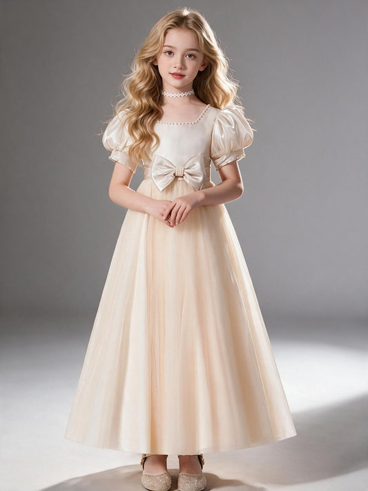 This is a square-neck flower girl dress for children with puff sleeves. It comes in champagne apricot, featuring a gentle and elegant look, perfect for piano performances and wedding flower girl duties.