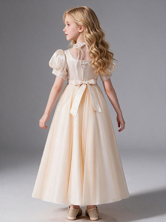 This is a square-neck flower girl dress for children with puff sleeves. It comes in champagne apricot, featuring a gentle and elegant look, perfect for piano performances and wedding flower girl duties.